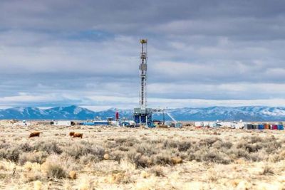 onshore oil rig in front of mountain range