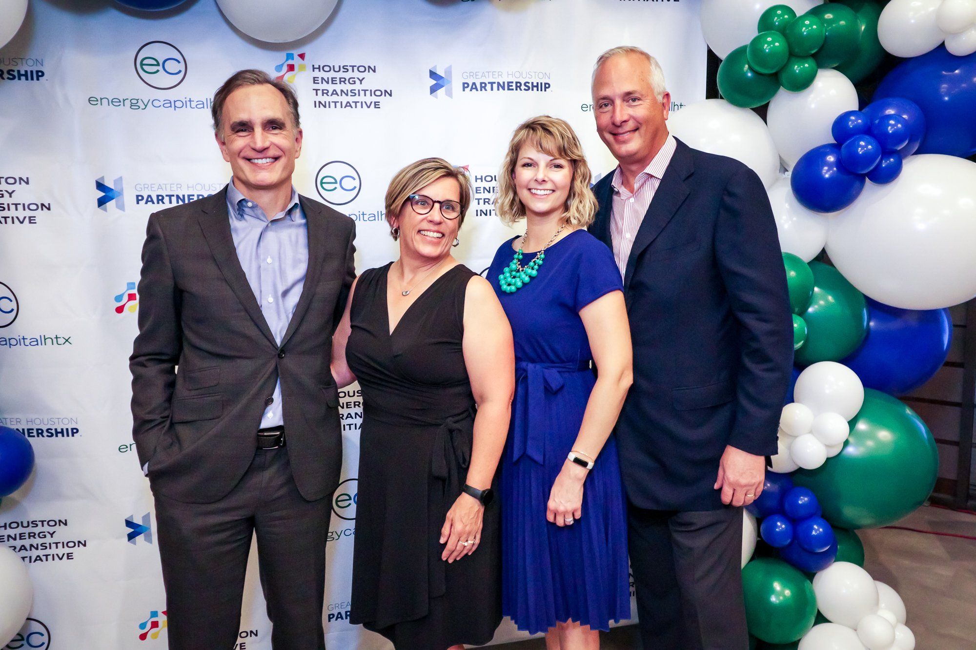 Four leaders in the Houston energy transition standing in front of a baloon backdrop