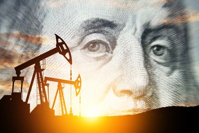 Oil and gas pump jacks at sunset with image of Benjamin Franklin layered over sky