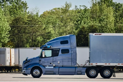 Sleek blue autonomous freight truck sits ready - with no driver inside